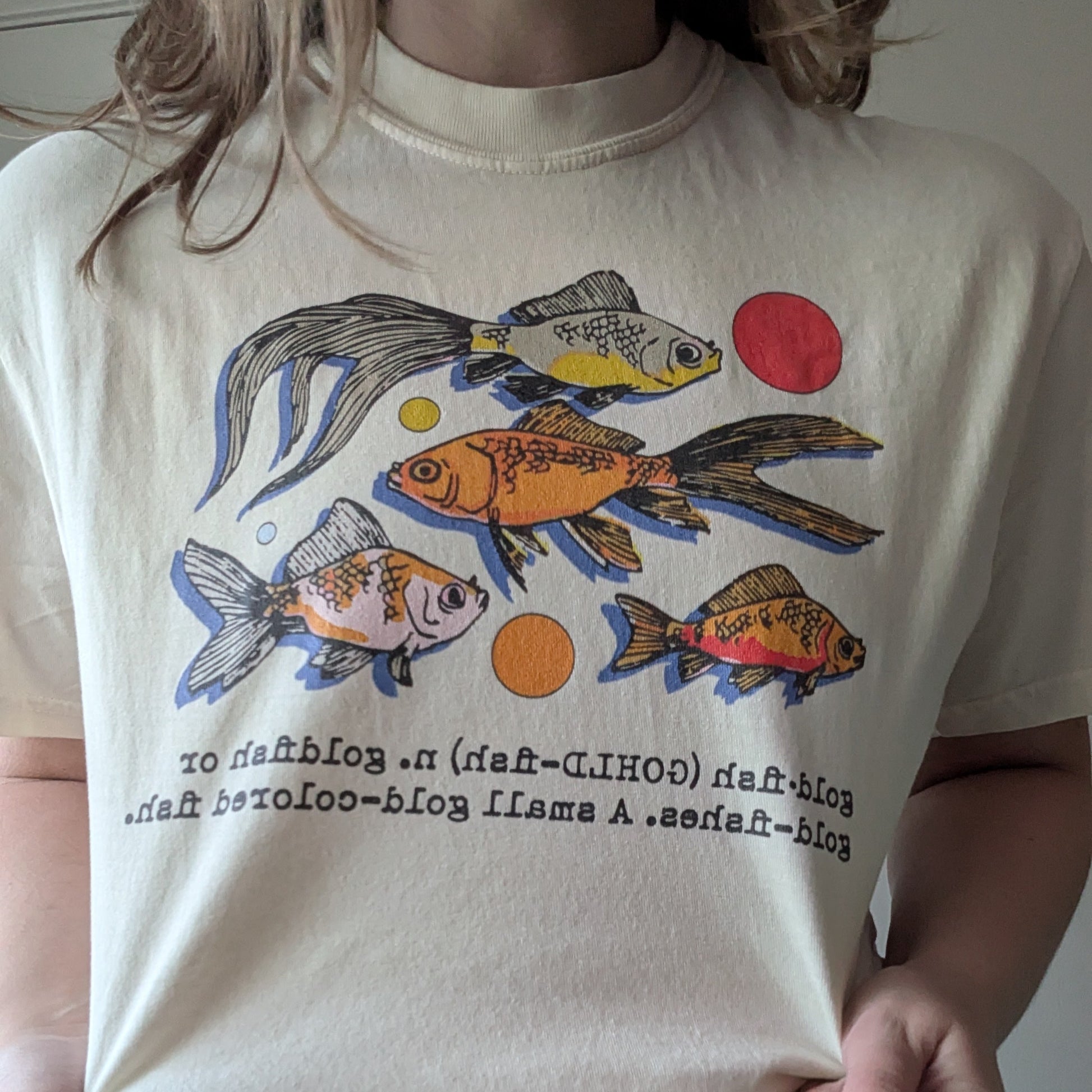 Person wearing a t-shirt with fish graphics and text